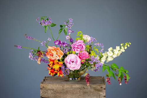 floral design multicolored flowers in vase on wooden surface pattern